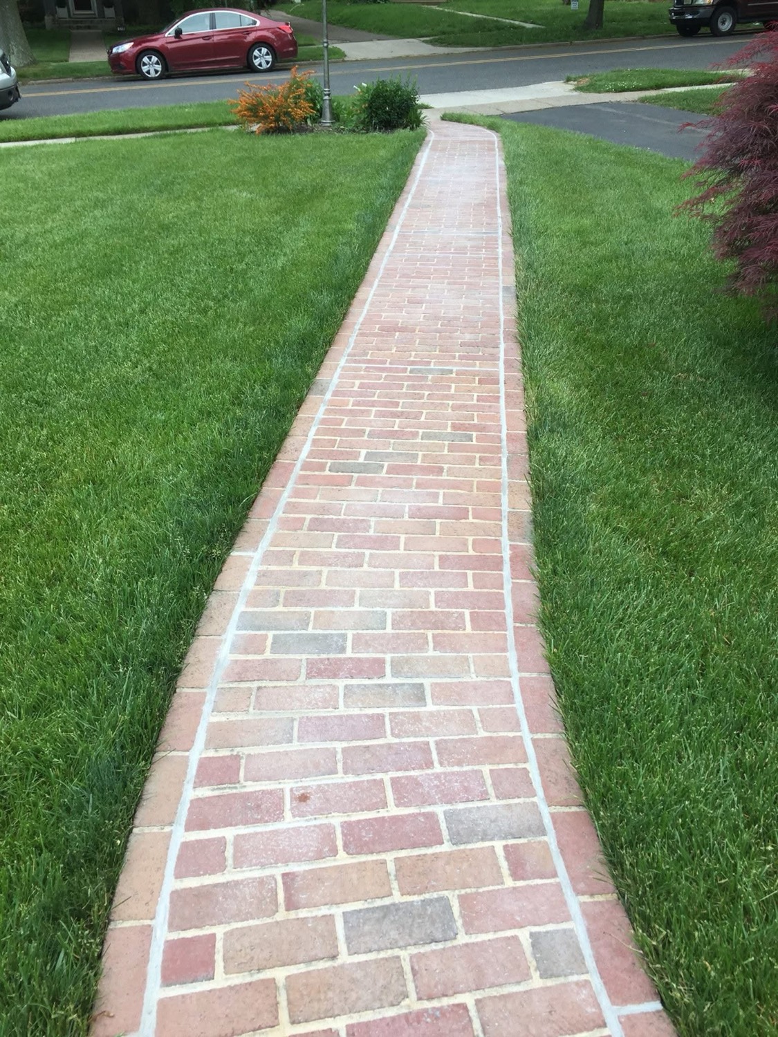 Real Eterno project — a curved brick-paver walkway running through a manicured South Jersey lawn